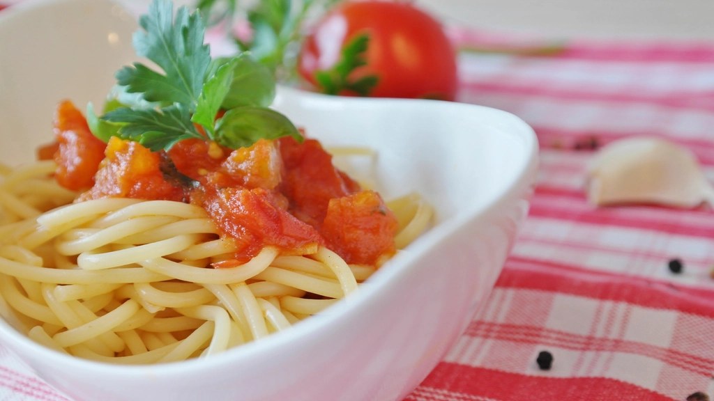 A bowl of spaghetti pomodoro with ripe tomatoes