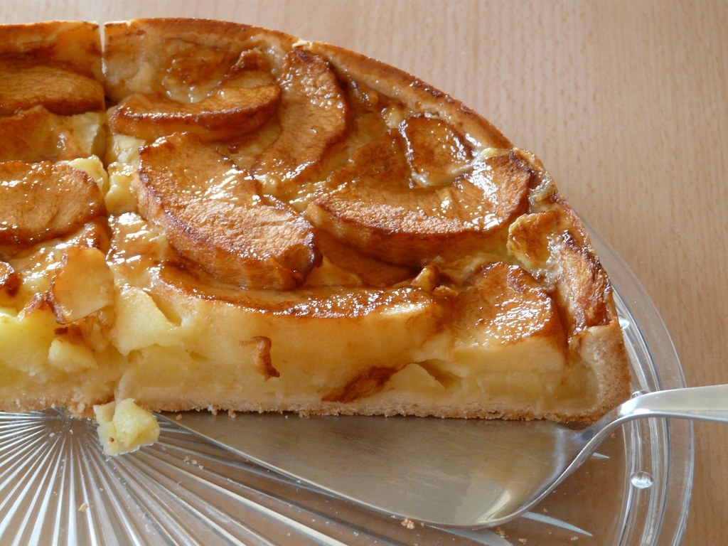 A slice of apple cake showing tender apple pieces