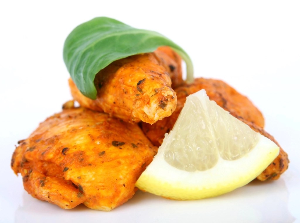 Roast chicken pieces served with a lemon wedge